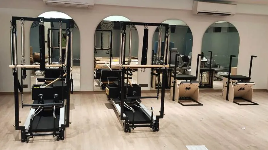 Pilates studio equipment in front of arched mirrors